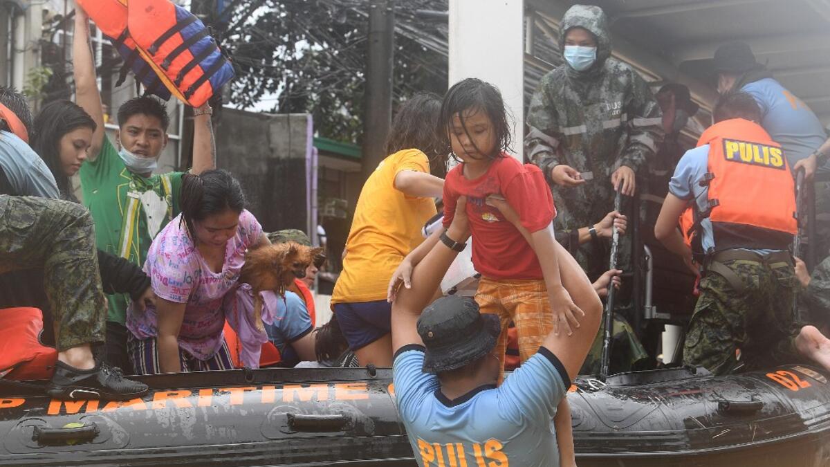 Rescuers evacuate residents from their flooded homes after Typhoon Vamco hit, in Marikina City, suburban Manila on November 12, 2020. Ted ALJIBE / AFP