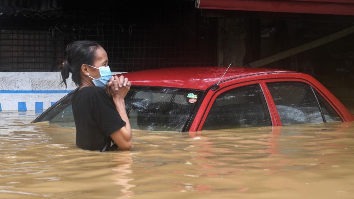 A resident makes her way through a flooded street to shelter after Typhoon Vamco hit, in Marikina City, suburban Manila on November 12, 2020. Ted ALJIBE / AFP