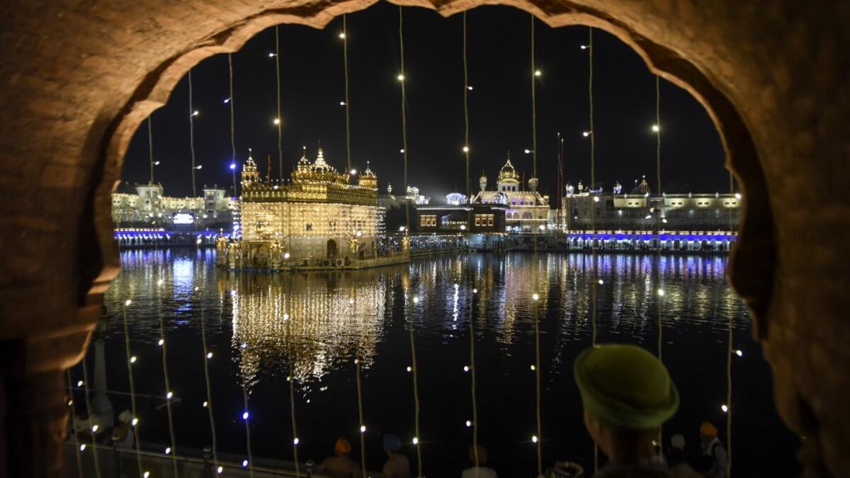 Sikh devotees pay respect on the eve of Bandi Chhor Divas, a Sikh festival coinciding with Diwali, the Hindu festival of light, at the illuminated Golden Temple in Amritsar on November 13, 2020. NARINDER NANU / AFP