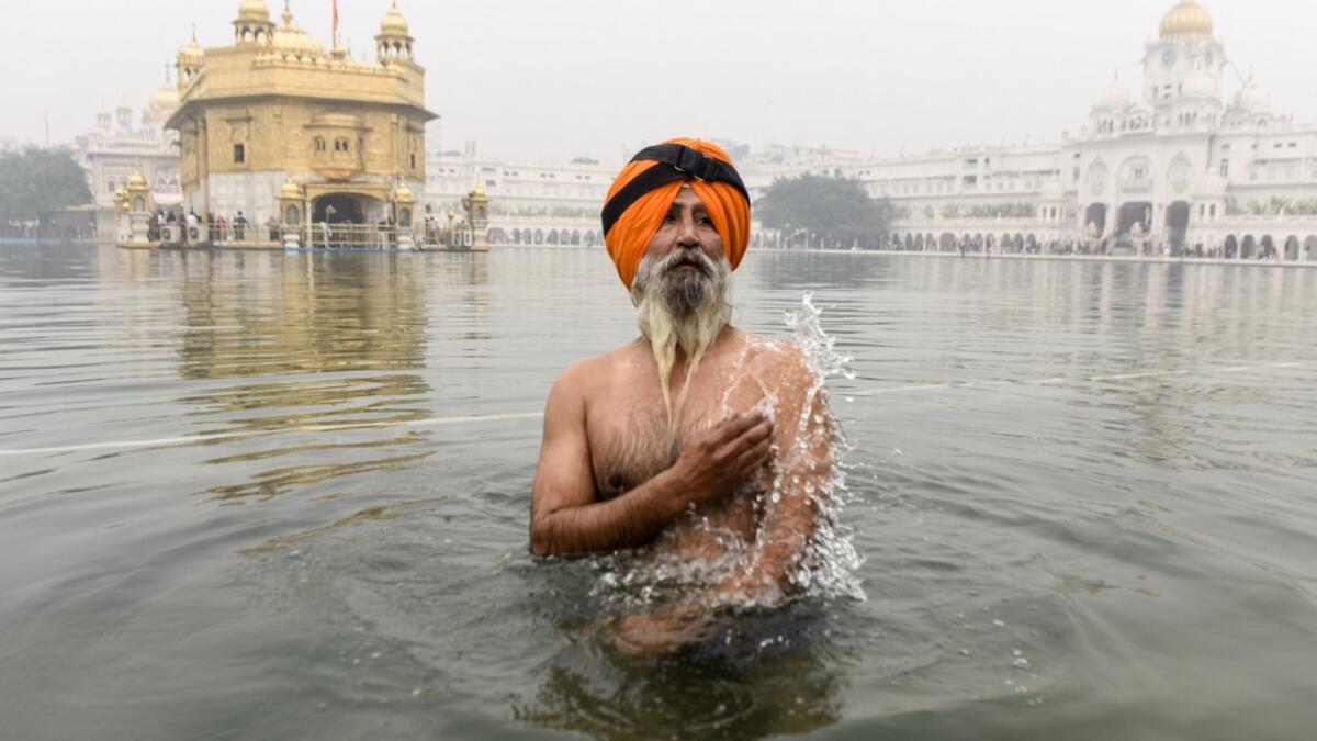 A Sikh devotee takes a dip in the holy sarovar (water tank) on the occasion of Bandi Chhor Divas, a Sikh festival coinciding with Diwali, the Hindu festival of light, at the Golden Temple in Amritsar on November 14, 2020. NARINDER NANU / AFP