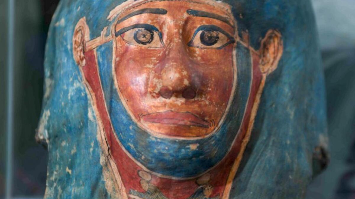 A picture shows a funerary mask on display during the unveiling of an ancient treasure trove of more than a 100 intact sarcophagi, at the Saqqara necropolis 30 kms south of the Egyptian capital Cairo, on November 14, 2020. Egypt announced the discovery of an ancient treasure trove of more than a 100 intact sarcophagi, the largest such find this year. The sealed wooden coffins, unveiled on site amid fanfare, belonged to top officials of the Late Period and the Ptolemaic period of ancient Egypt. They were fou