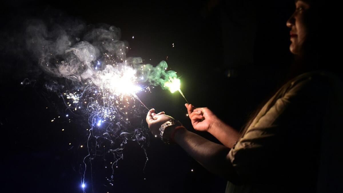 A woman lights sparklers during Diwali, the Hindu Festival of Lights, in Allahabad on November 14, 2020. SANJAY KANOJIA / AFP