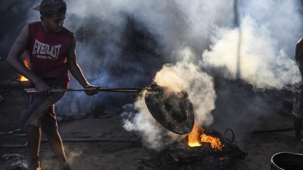 In this picture taken on November 12, 2020 dockyard workers carries maintenance works on the banks of the Buriganga river in Char Kaliganj on the outskirts of Dhaka. Rivers are the lifeblood of the delta nation of 168 million people where much of the low-lying land is accessed via boat, with Bangladesh's strong economic growth of recent years fuelling more investments in new and bigger ships. Munir UZ ZAMAN / AFP