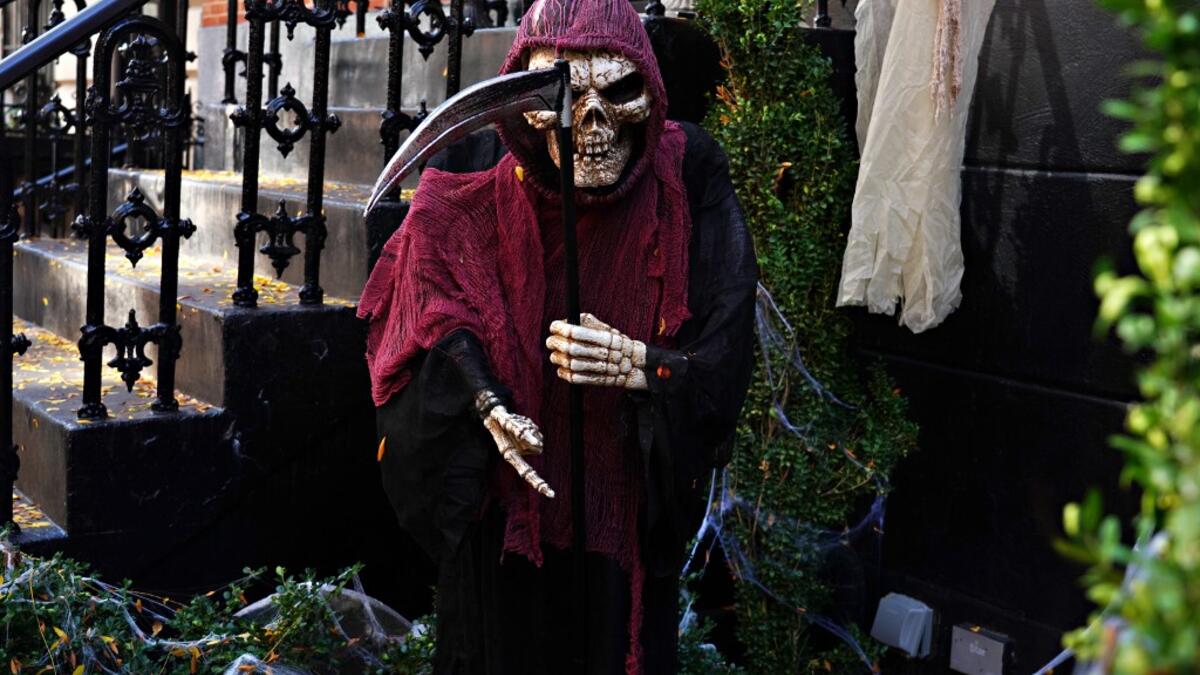 An Upper East Side home is decorated with a Grim Reaper skeleton for Halloween on October 31, 2020 in New York City. Many Halloween events have been canceled or adjusted with additional safety measures due to the ongoing coronavirus (COVID-19) pandemic. Cindy Ord/Getty Images/AFP