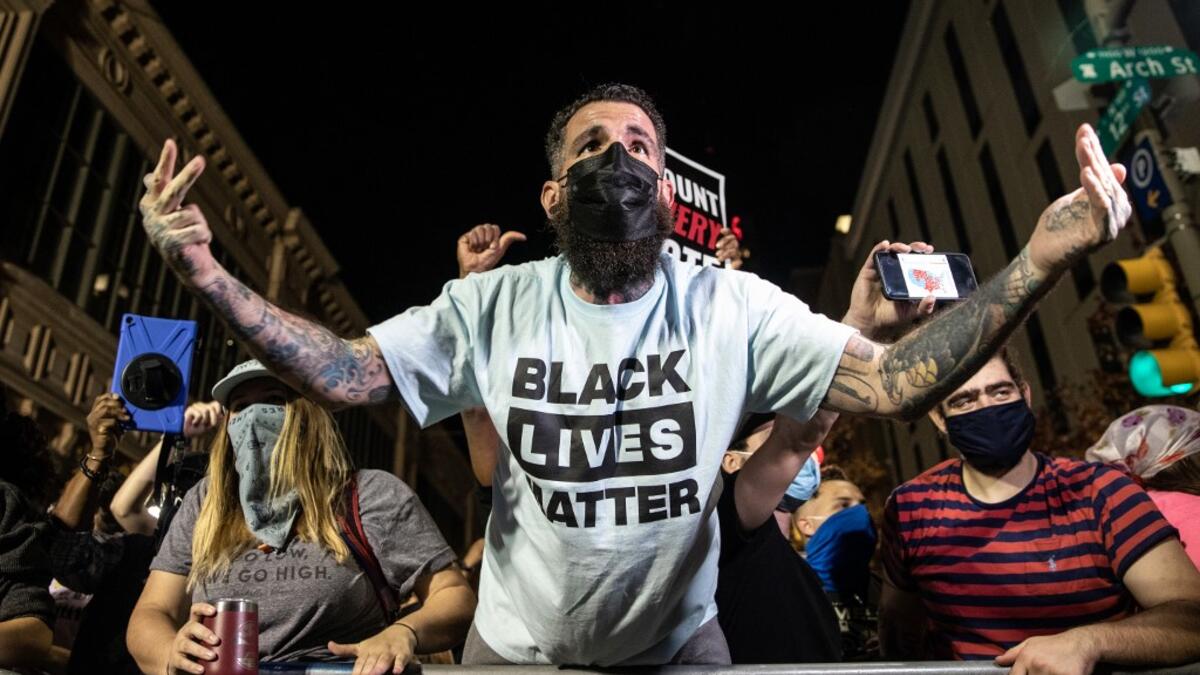 People celebrating the election victory of Joe Biden taunt supporters of U.S President Donald Trump from across the street while celebrating outside the Philadelphia Convention Center after Joe Biden was declared winner of the 2020 presidential election on November 07, 2020 in Philadelphia, Pennsylvania. Chris McGrath / GETTY IMAGES NORTH AMERICA / Getty Images via AFP