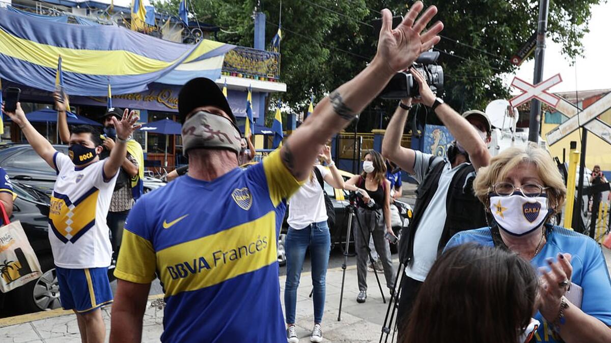 Argentine football star Diego Maradona fans sing slogans outside the entrance of Argentina's Boca Juniors La Bombonera stadium where people gather to mourn his death in Buenos Aires, on November 25, 2020. (AFP/File)