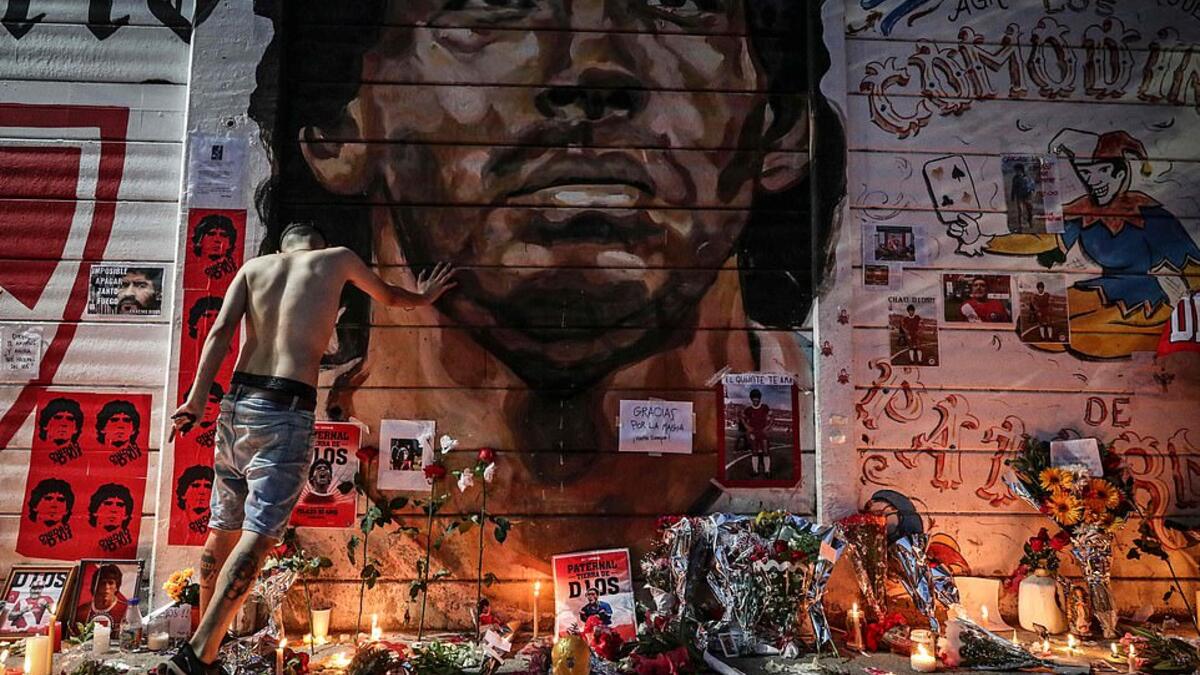 Flowers, posters and other items are left at a makeshift shrine outside the stadium named after Maradona in Buenos Aires. AFP/File