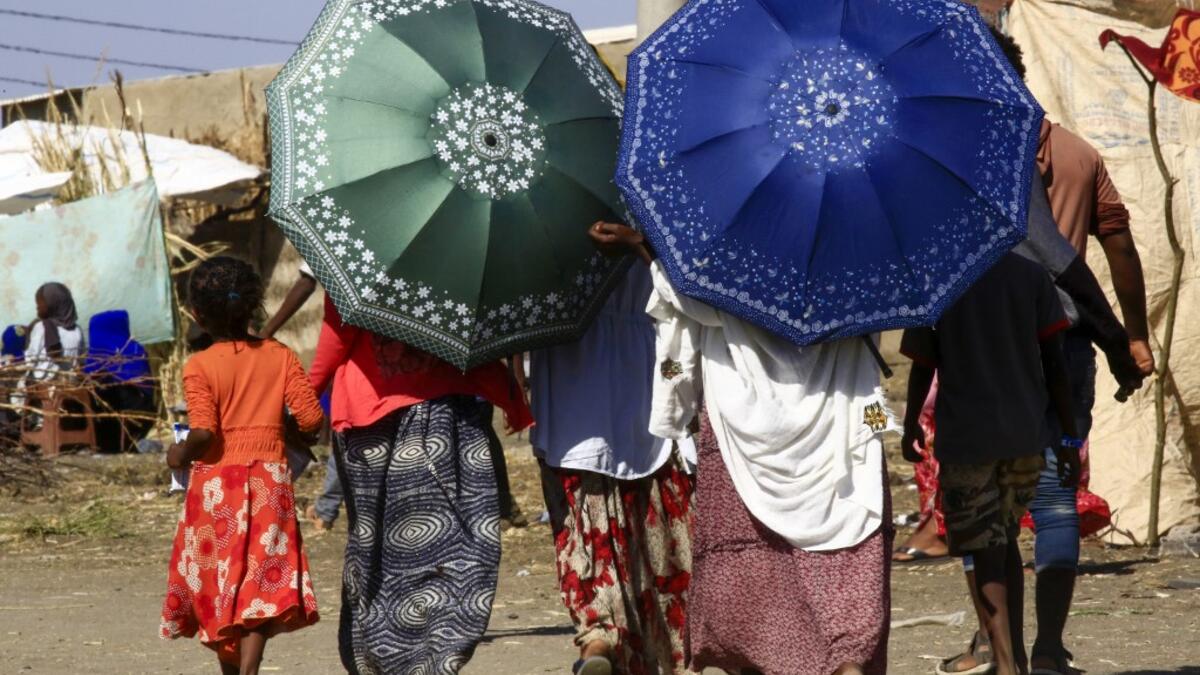 Ethiopian refugees, who fled the fighting in Tigray Region, are pictured walking at a border reception centre (Village 8) in Gedaref State, eastern Sudan, on November 29, 2020. ASHRAF SHAZLY / AFP