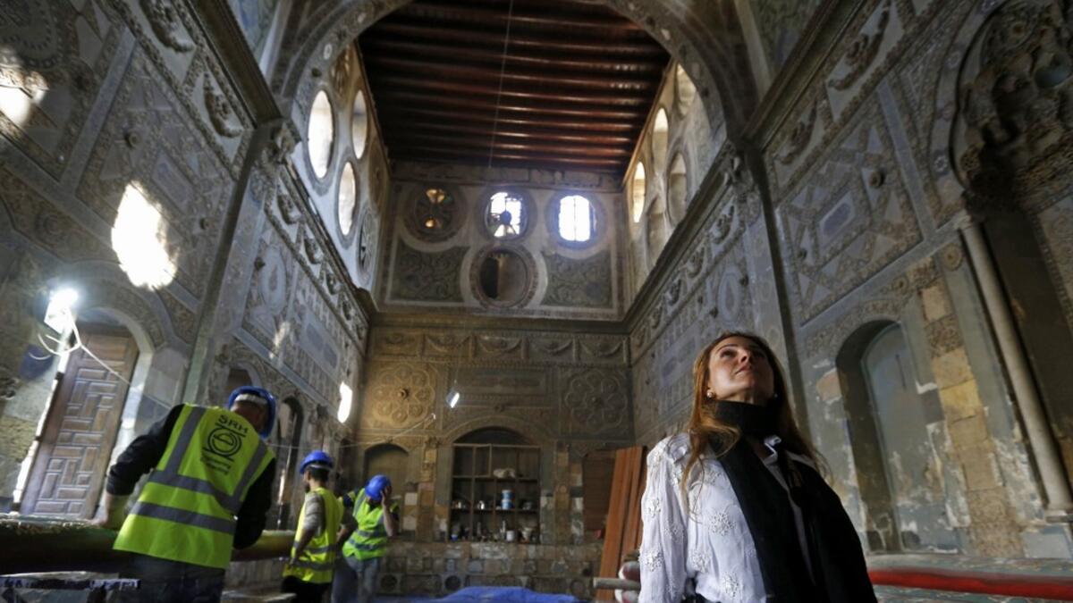 Rania Kataf, 35-year-old Syrian, walks past restoration workers at a palatial Ottoman-era home called Beit al-Quwatli for her digital archive in the old part of Syria's capital Damascus on November 11, 2020. LOUAI BESHARA / AFP