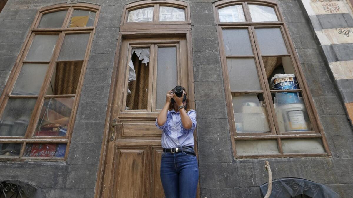 Rania Kataf, 35-year-old Syrian, captures images of the city's famed houses for her digital archive in the old part of Syria's capital Damascus on October 28, 2020. The old city of the Syrian capital is famed for its elegant century-old houses, usually two storeys built around a leafy rectangular courtyard with a carved stone fountain at its centre.LOUAI BESHARA / AFP