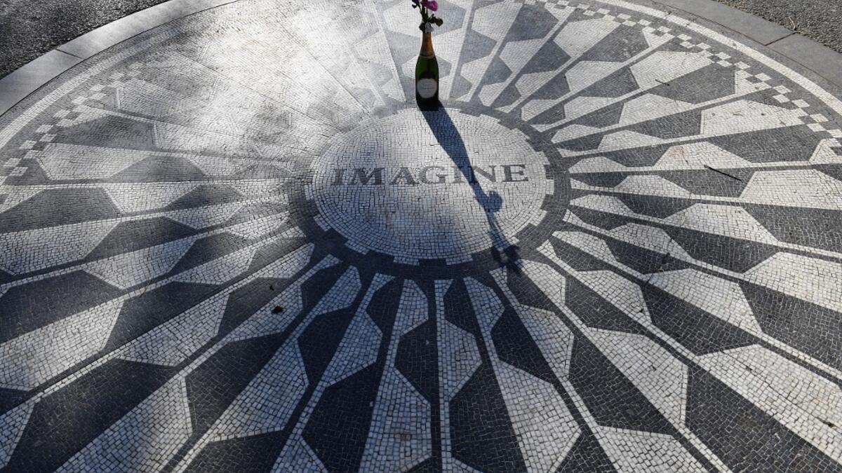 A champagne bottle with flowers adorns the "Imagine" mosaic at the Strawberry Fields Memorial for John Lennon, in Central Park on December 3, 2020 in New York City. On December 8, 1980, the filigree gates of New York's Dakota residence across from Central Park went down in history as the spot John Lennon was shot dead. But for nearly a decade prior to his shock murder, the former Beatle's adopted hometown was where he rediscovered life. Angela Weiss / AFP