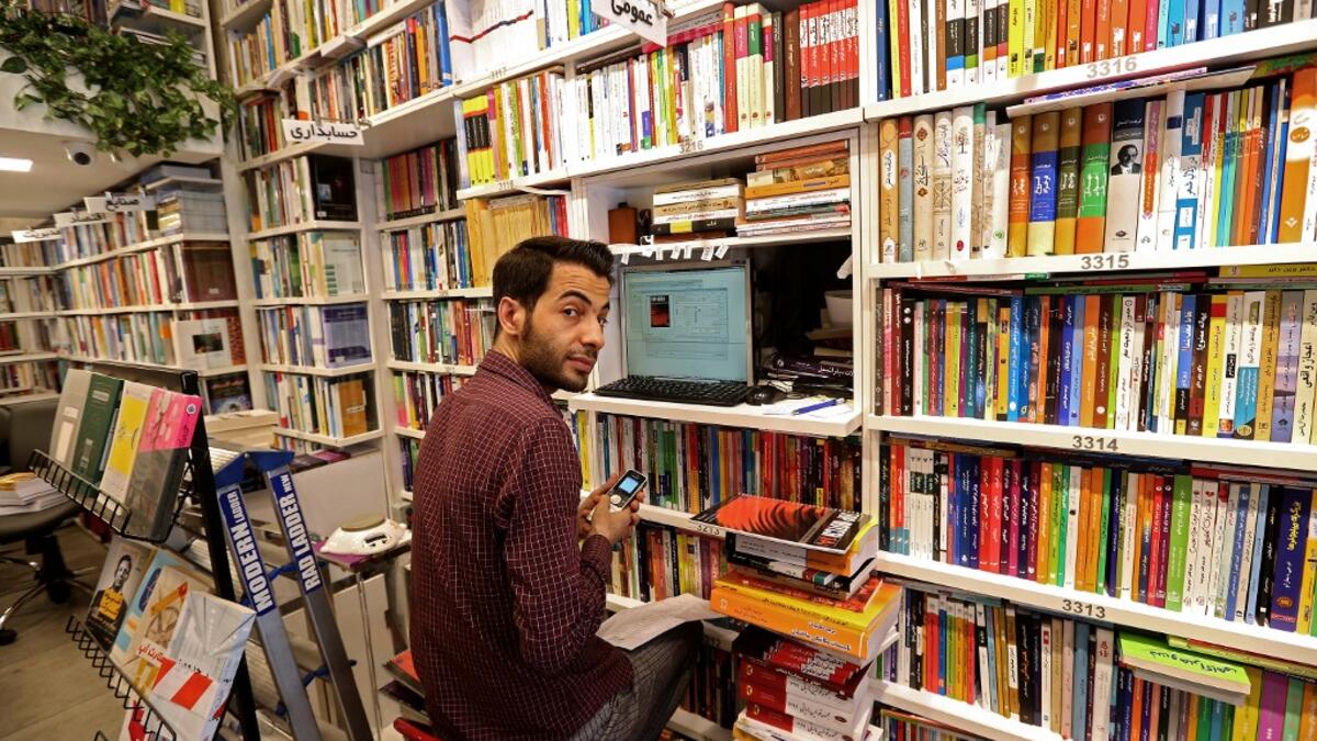 An Iranian employee works on a computer at a bookstore in Tehran's Enqelab (Revolution) street, on September 8, 2020. ATTA KENARE / AFP