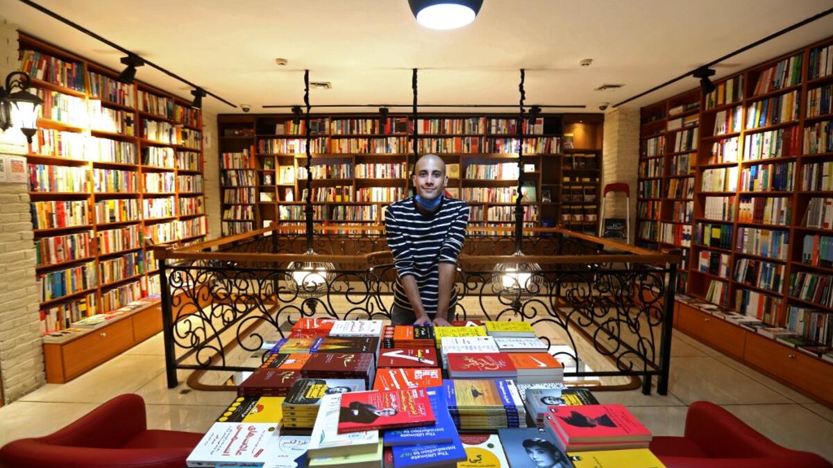 An Iranian employee poses for a picture at a bookstore in Tehran's Enqelab (Revolution) street, on September 8, 2020. ATTA KENARE / AFP