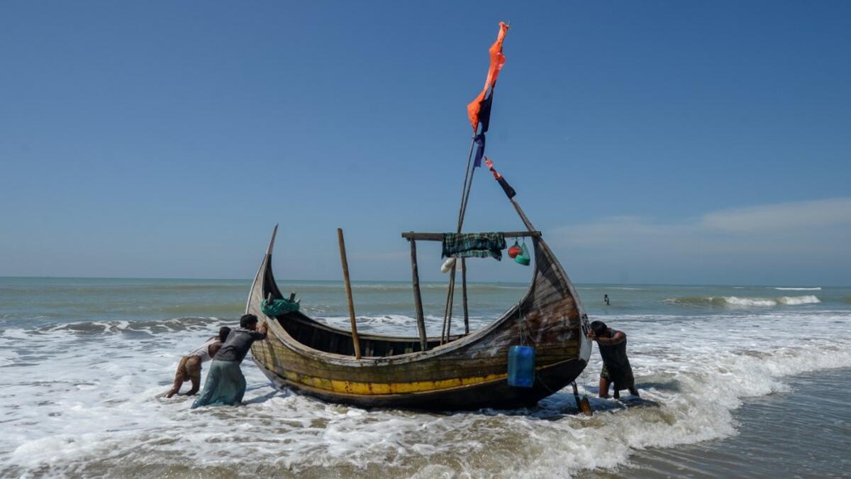 In this photograph taken on October 10, 2020, fishermen set out on a fishing boat at Sabrang beach area, a boarding point of Rohingya refugees migrating to Malaysia by boat. Boatloads of Rohingya landing across Southeast Asia are victims of complex human trafficking networks run by a dizzying web of players, from crime bosses and corrupt cops to poor fishermen, rickshaw drivers and even Rohingya themselves. Munir UZ ZAMAN / AFP
