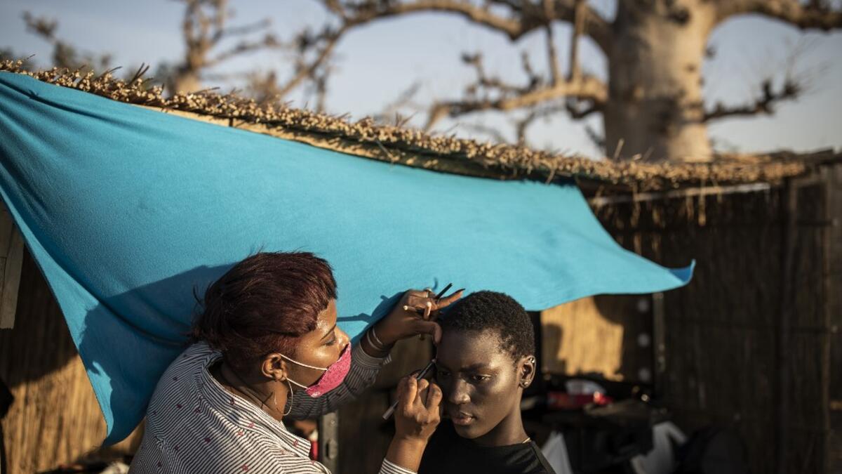 A fashion model get her make-up and hair done ahead of the start of Dakar Fashion Week in Dakar on December 12, 2020. JOHN WESSELS / AFP