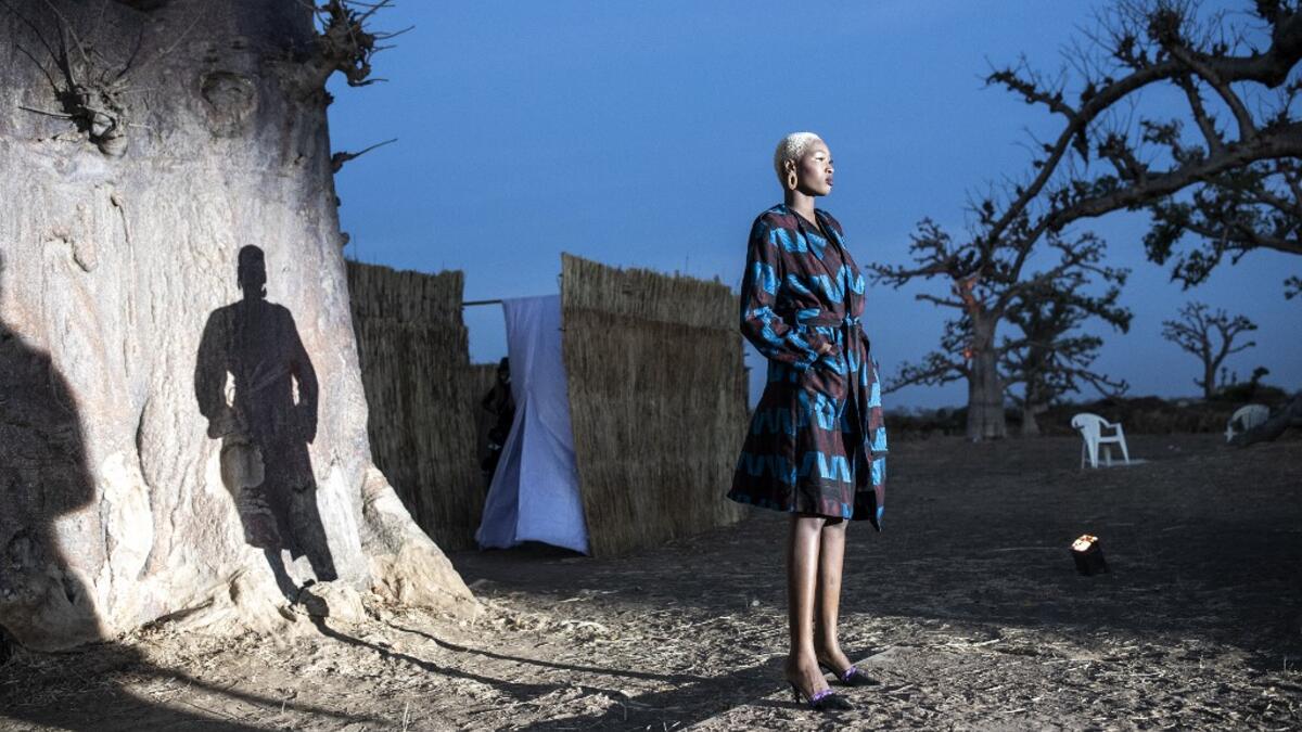 A fashion model poses at the start of the runway during Dakar Fashion Week in Dakar on December 12, 2020. JOHN WESSELS / AFP