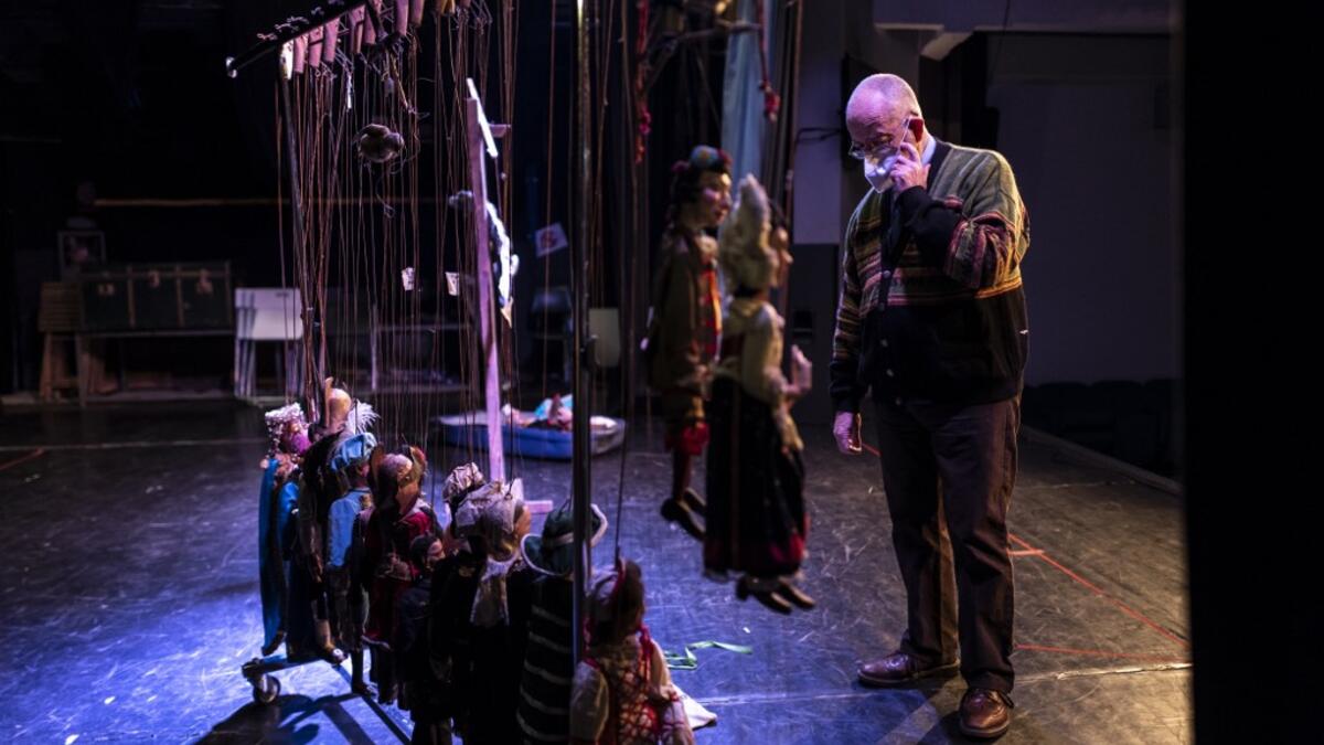 Augusto Grilli checks his puppets on the stage at the " Alfa Theatre" in Turin, on November 30, 2020. The Grilli family has a collection of more than 20,000 objects from around the world, everything from theatres, marionettes and glove puppets to shadow figures and silhouettes. A long-time dream of Grilli and his wife Mariarosa, 78, the museum is due to open in 2023 in Turin, financed both privately and publicly with the help of different institutions.  Marco Bertorello / AFP