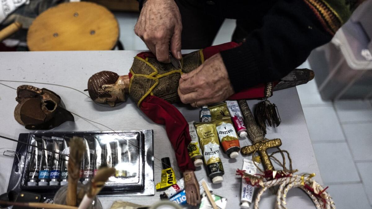 Augusto Grilli repairs a puppet in his " Alfa Theatre" laboratory in Turin, on November 30, 2020. The Grilli family has a collection of more than 20,000 objects from around the world, everything from theatres, marionettes and glove puppets to shadow figures and silhouettes. A long-time dream of Grilli and his wife Mariarosa, 78, the museum is due to open in 2023 in Turin, financed both privately and publicly with the help of different institutions.  Marco Bertorello / AFP