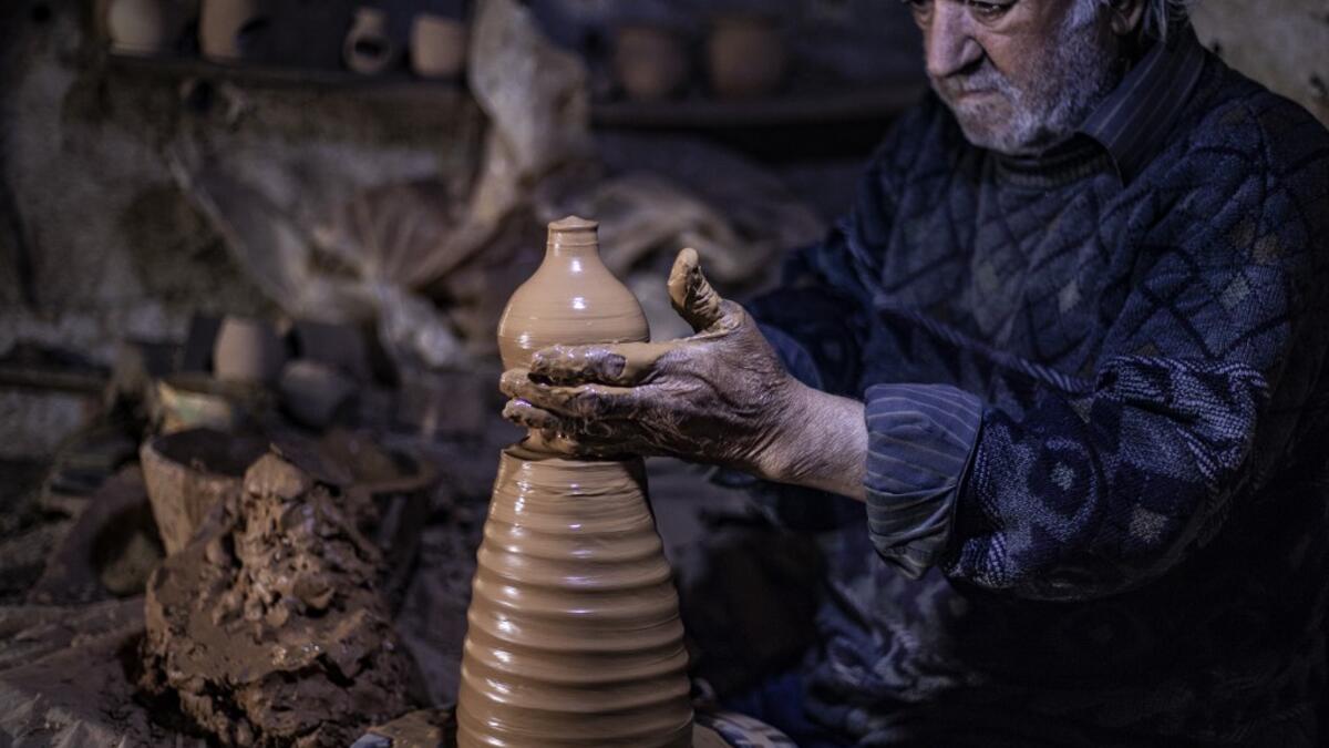 Syrian-Armenian potter Misak Antranik Petros uses an ancient pottery wheel to churn different types of pots at his workshop located inside an ancient mud-brick house near the city of Qamishli in Syria's northeastern Hasakeh province, on December 19, 2020. Petros was only a teenager when he had to take over for his sick father and become the main potter of the family. He has since become a master of the craft, and is keen to pass his skills on.  Delil SOULEIMAN / AFP