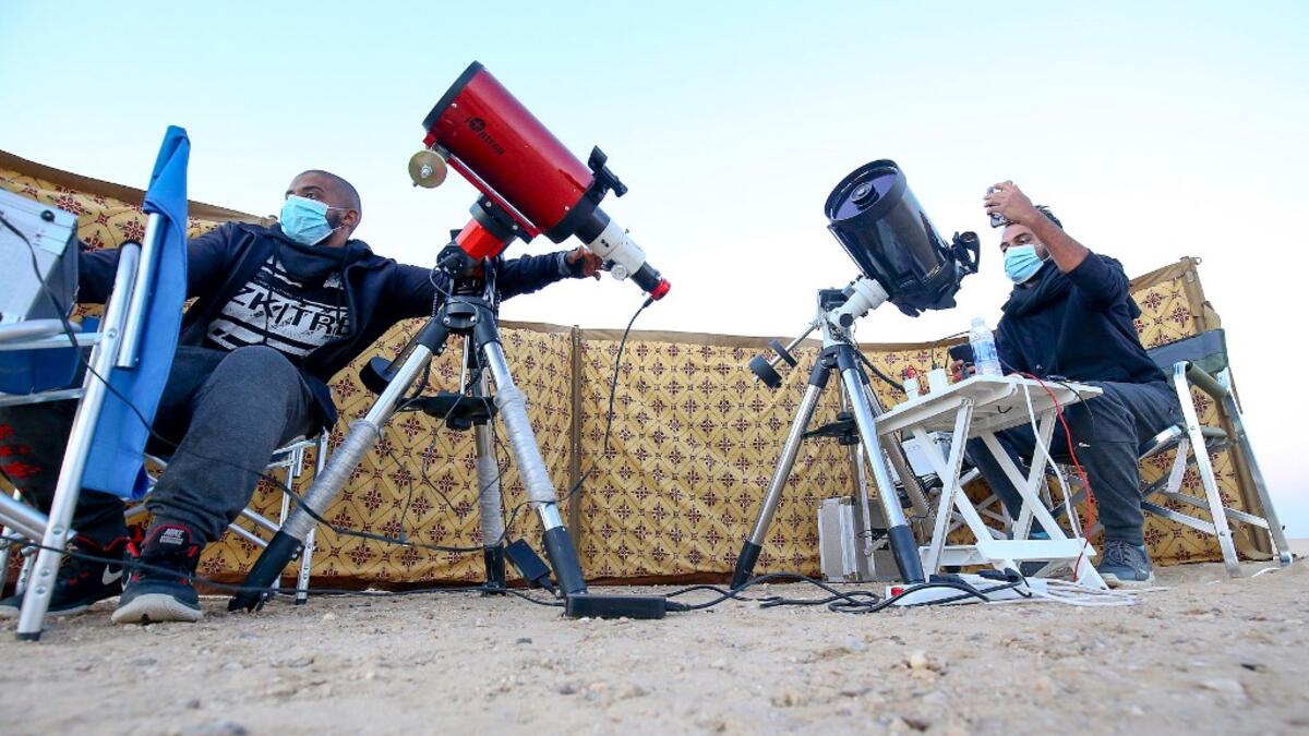 Kuwaiti astrophotographers Mohammad al-Obaidi (R) and Abdullah al-Harbi follow the great conjunction between Jupiter and Saturn in al-Salmi district, a desert area 120 kms west of Kuwait City, on December 21, 2020. The great conjunction refers to the alignment of Jupiter and Saturn. YASSER AL-ZAYYAT / AFP
