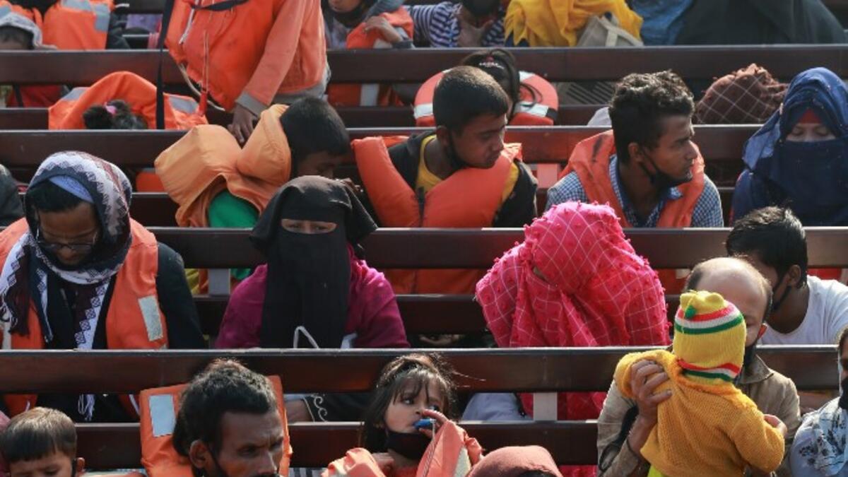 Rohingya refugees sit on a Bangladesh Navy ship as they are relocated to the controversial flood-prone island Bhashan Char in the Bay of Bengal, in Chittagong on December 29, 2020. Rehman ASAD / AFP