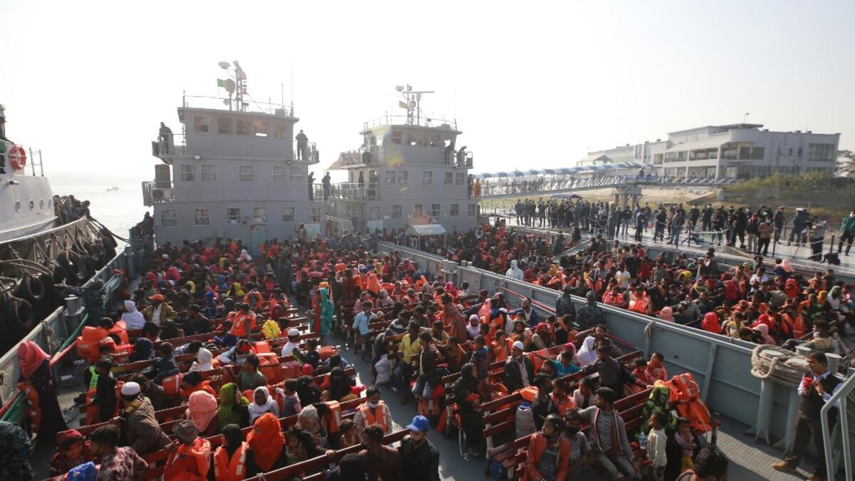 Rohingya refugees sit on a Bangladesh Navy ship as they are relocated to the controversial flood-prone island Bhashan Char in the Bay of Bengal, in Chittagong on December 29, 2020. Rehman ASAD / AFP