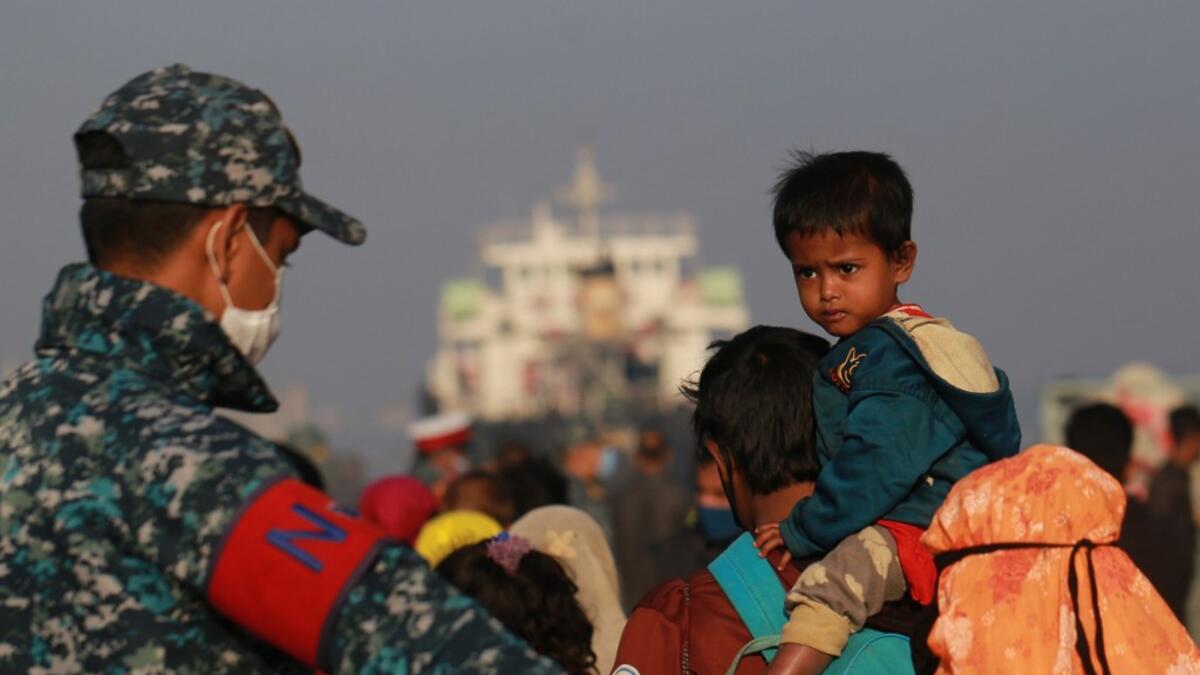 Rohingya refugees embark on a Bangladesh Navy ship as they are relocated to the controversial flood-prone island Bhashan Char in the Bay of Bengal, in Chittagong on December 29, 2020. Rehman ASAD / AFP
