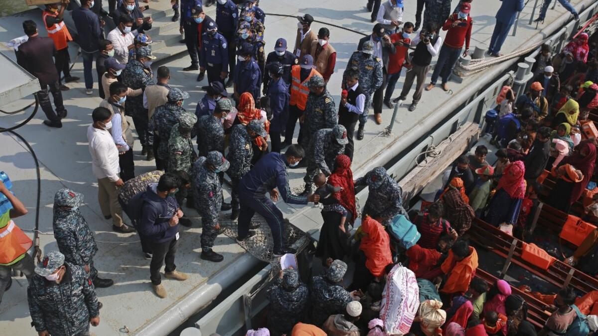 Rohingya refugees disembark from a Bangladesh Navy ship as they are relocated to the controversial flood-prone island Bhashan Char in the Bay of Bengal, in Chittagong on December 29, 2020. REHMAN ASAD / AFP