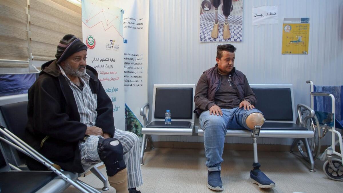 Patients wait for a consultation at the National Center for Artificial Limbs, in Libya's port city of Misrata, on December 17, 2020. With Libya's health sector left in tatters by its multiple conflicts since the 2011 revolution, war-wounded Libyans are often sent abroad for treatment, at the expense of the state. However, A national centre for prostheses, being established in Misrata, already has a patient waiting list of more than 3,000 amputees