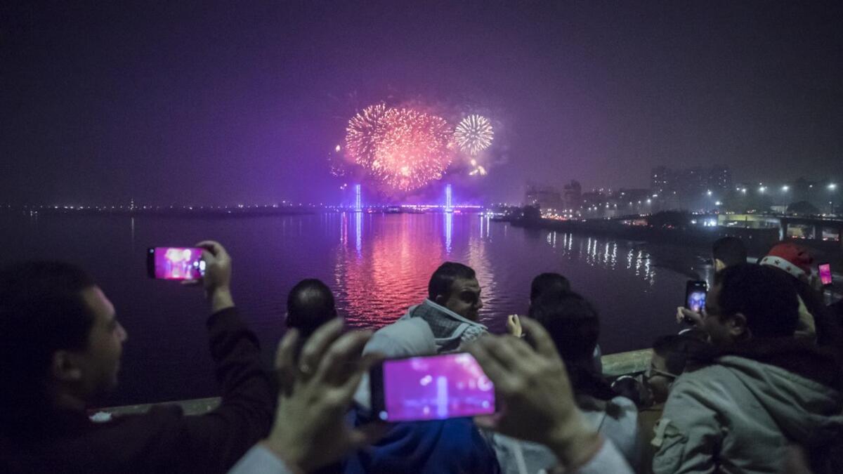 People watch fireworks explode over the River Nile in the Egyptian capital Cairo during New Year's Eve celebrations on December 31, 2020. Khaled DESOUKI / AFP