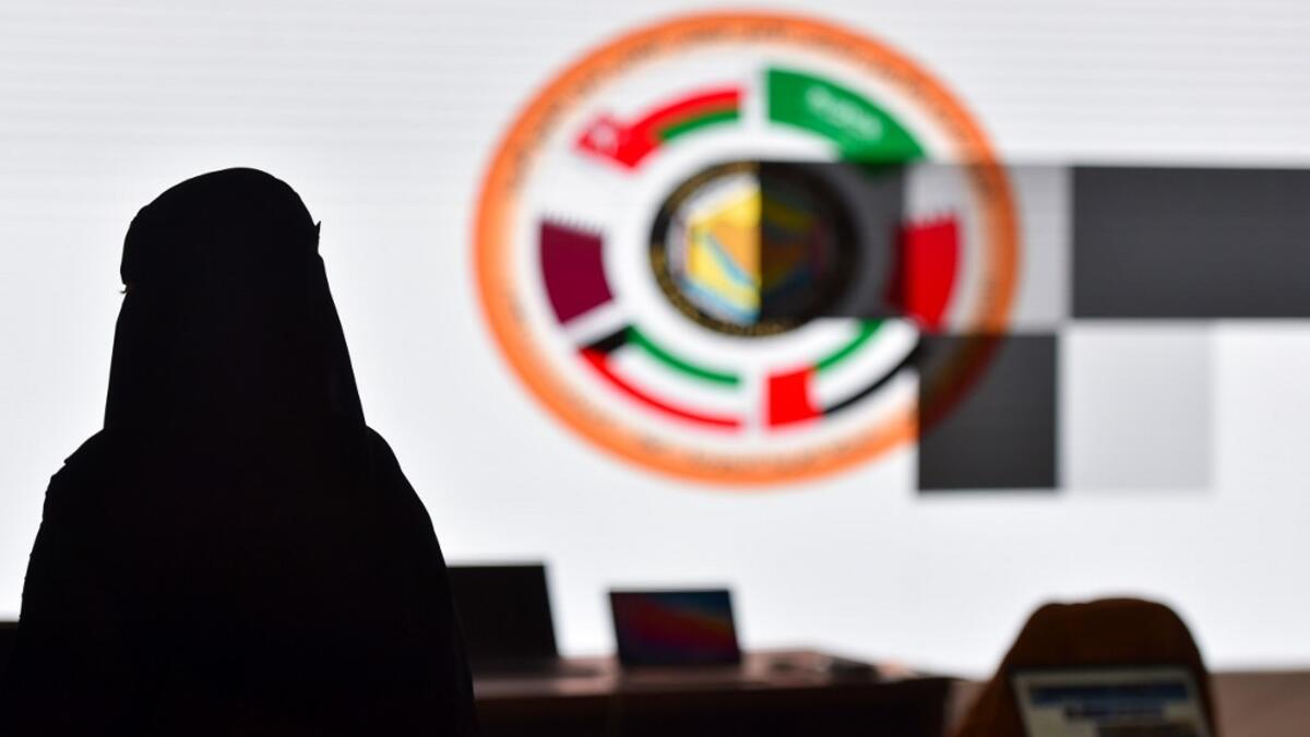 A Saudi journalist is pictured in front of the logo of the Gulf Cooperation Council (GCC) at the media centre ahead of the 41st summit in the city of Al-Ula in northwestern Saudi Arabia on January 5, 2021. FAYEZ NURELDINE / AFP