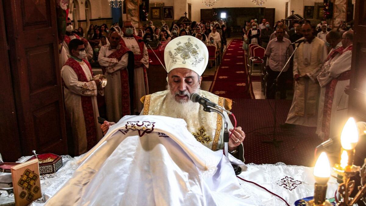 A Sudanese Coptic priest heads the Christmas midnight mass at the capital Khartoum's Martyrs Church late on January 6, 2021, as the Orthodox Christian faith uses the old Julian calendar in which Christmas falls 13 days after the date in the more widespread Gregorian calendar.  Ebrahim HAMID / AFP