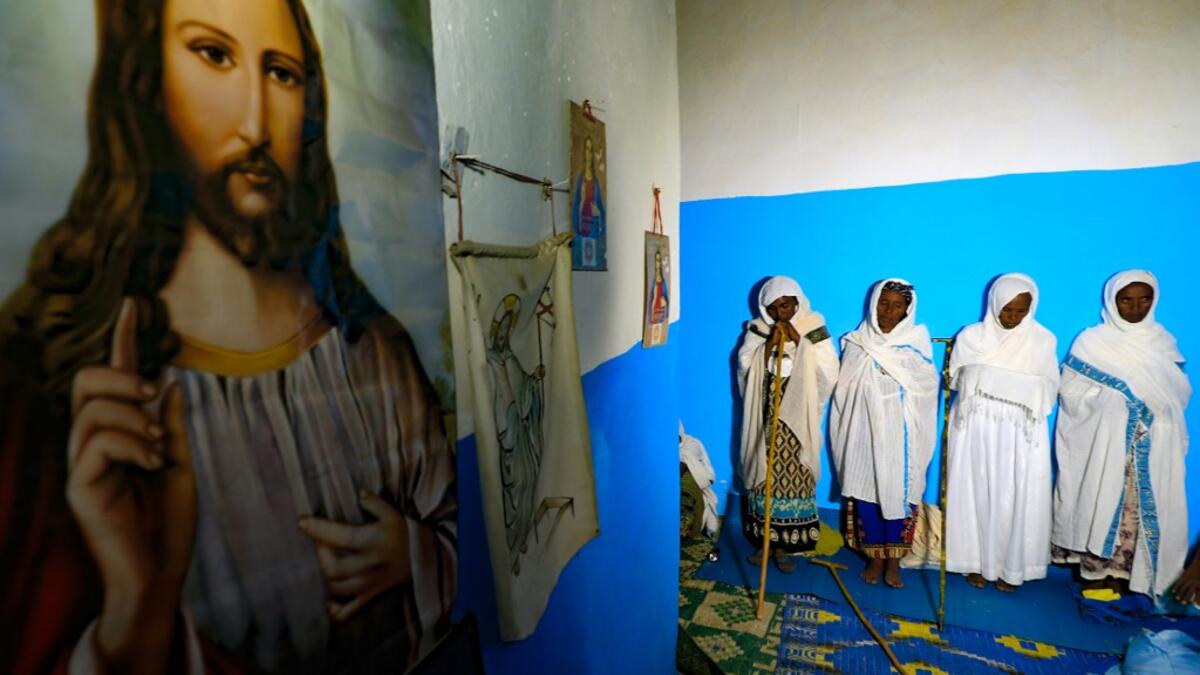 Ethiopian refugees who fled the Tigray conflict attend the Coptic Christmas midnight mass with local believers, inside an Ethiopian Orthodox church built by former Ethiopian refugees, at a village next to Um Raquba refugee camp in Gedaref, eastern Sudan,late on January 6, 2021. ASHRAF SHAZLY / AFP