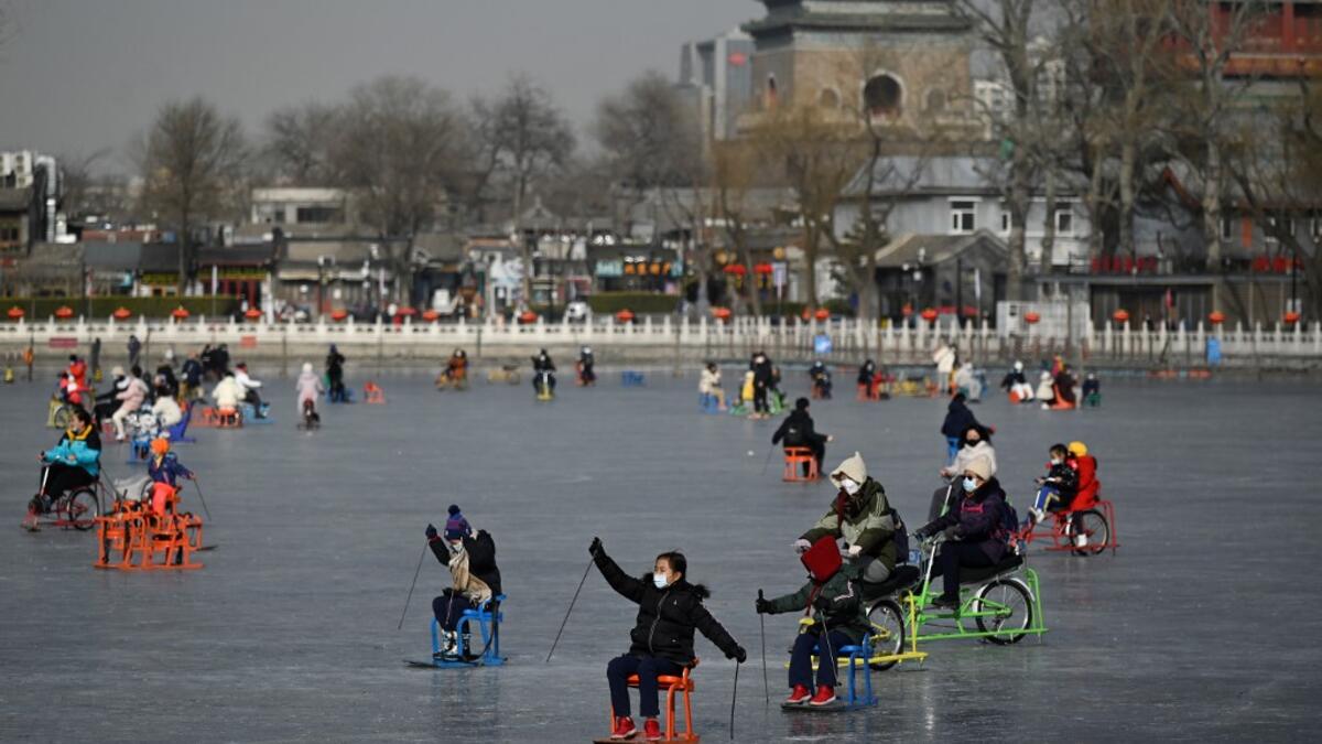 People use sleds on a frozen lake in Beijing on January 12, 2021. WANG Zhao / AFP
