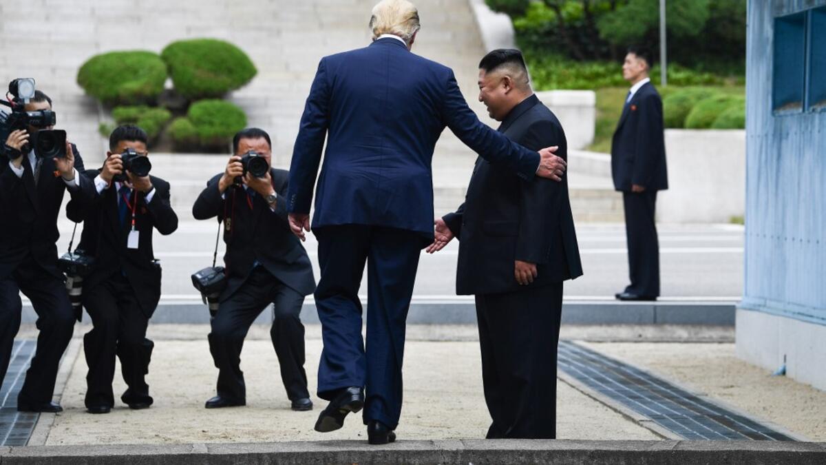 AFP presents a retrospective photo package of 60 pictures marking the 4-year presidency of President Trump. US President Donald Trump steps into the northern side of the Military Demarcation Line that divides North and South Korea, as North Korea's leader Kim Jong Un looks on, in the Joint Security Area (JSA) of Panmunjom in the Demilitarized zone (DMZ) on June 30, 2019. Brendan Smialowski / AFP