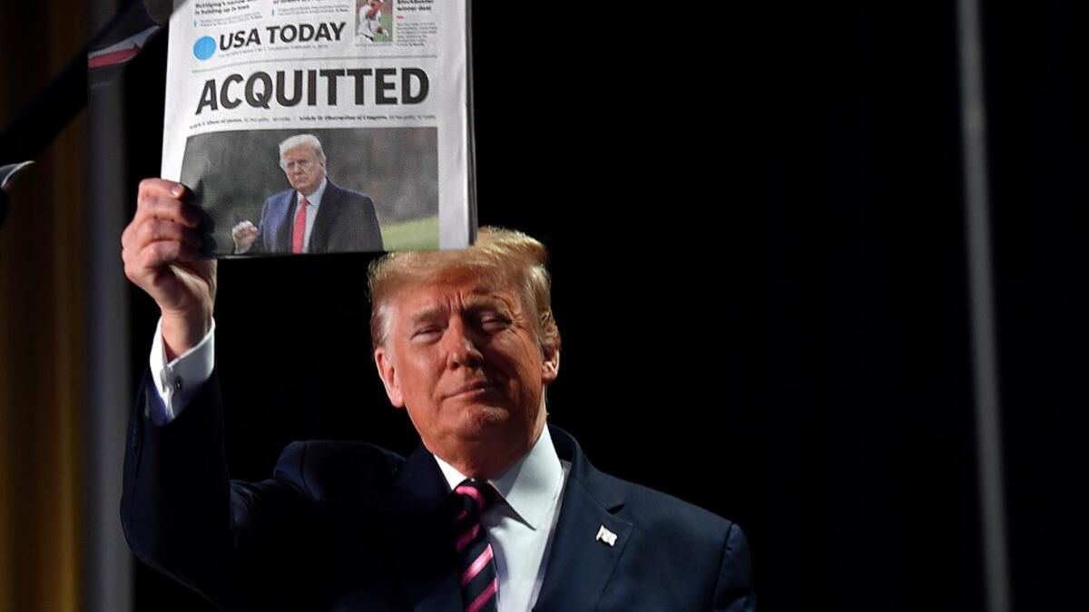 US President Donald Trump holds up a newspaper that displays a headline "Acquitted" as he arrives to speak at the 68th annual National Prayer Breakfast on February 6, 2020 in Washington,DC. President Donald Trump said Thursday that he suffered a "terrible ordeal" during his impeachment. In his first public comments since being acquitted by the Senate of abuse of office, he said he had been "put through a terrible ordeal by some very dishonest and corrupt people." "They have done everything possible to destr
