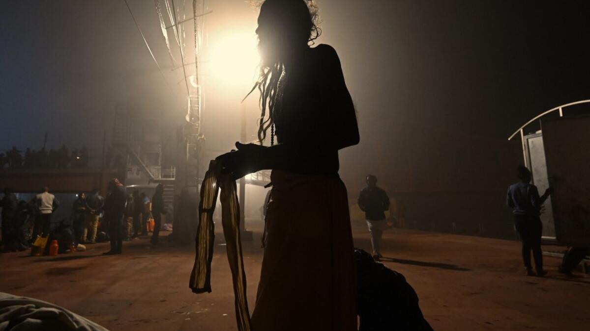A Hindu devotee prepares to take a holy dip in the waters of river Ganges during Makar Sankranti, a day considered to be of great religious significance in Hindu mythology, on the first day of the religious Kumbh Mela festival in Haridwar on January 14, 2021. Money SHARMA / AFP