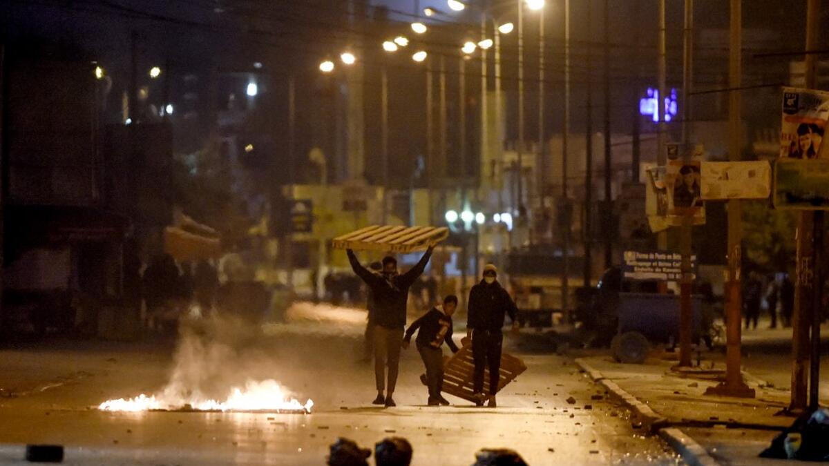 Protesters block a street during clashes with security forces in the Ettadhamen city suburb on the northwestwern outskirts of Tunisia's capital Tunis on January 17, 2021, amidst a wave of nightly protests in the North African country. FETHI BELAID / AFP