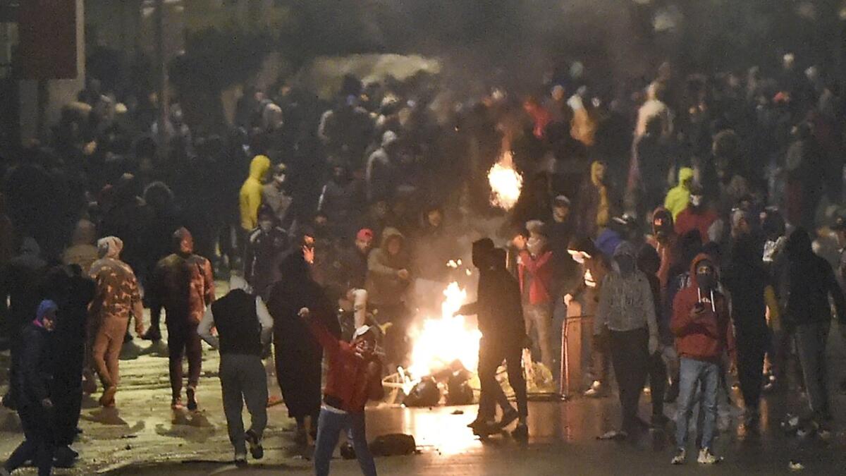 Tunisian protesters block a street during clashes with security forces in the Ettadhamen city suburb on the northwestwern outskirts of Tunis on January 18, 2021, amidst a wave of nightly protests in the North African country. The social unrest comes at a time of economic crisis, worsened by the pandemic, that has sparked rapid inflation and high youth unemployment and led many people to leave Tunisia. FETHI BELAID / AFP