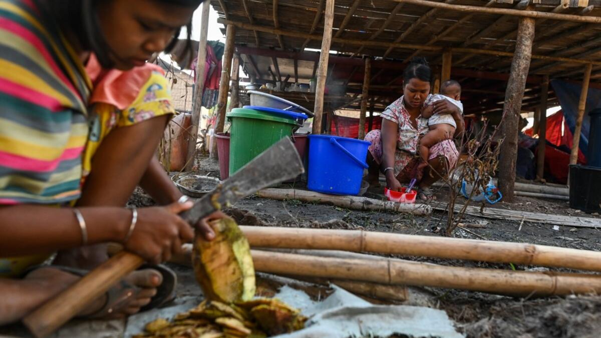 This photo taken on January 11, 2021 shows Chin people preparing food in Bethel village in Hmawbi, on the outskirts of Yangon, where hundreds of members of the Chin ethnic community have settled after being displaced by fighting between Myanmar's military and the Arakan Army in the country's north.  Ye Aung THU / AFP