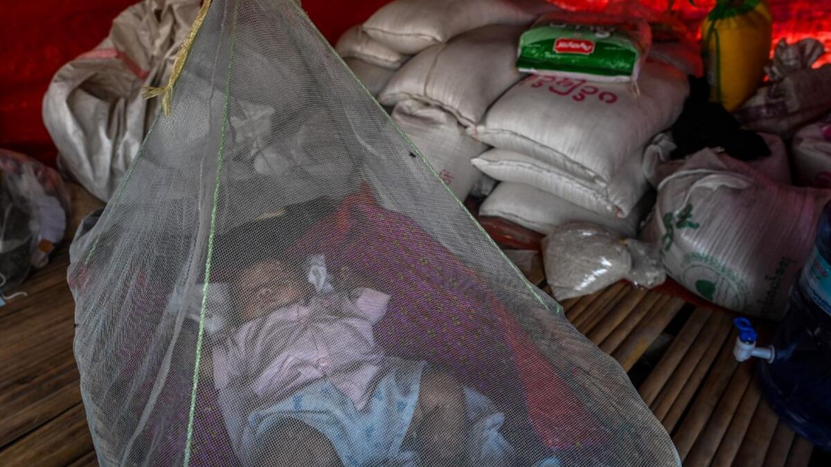 This photo taken on January 11, 2021 shows a Chin baby sleeping under a mosquito net in Bethel village in Hmawbi, on the outskirts of Yangon, where hundreds of members of the Chin ethnic community have settled after being displaced by fighting between Myanmar's military and the Arakan Army in the country's north.  Ye Aung THU / AFP