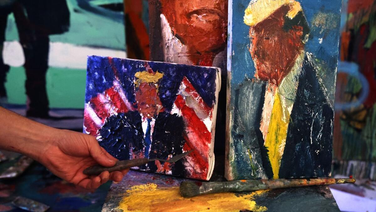 Israeli painter Iddo Markus displays some of his paintings of former US president Donald Trump, at his studio in the northern port city of Haifa, on January 22, 2021. Markus became fascinated by the "tragic figure" of Donald Trump, and the walls and floor of his studio are packed with some 120 portraits of the former US presidents. Emmanuel DUNAND / AFP