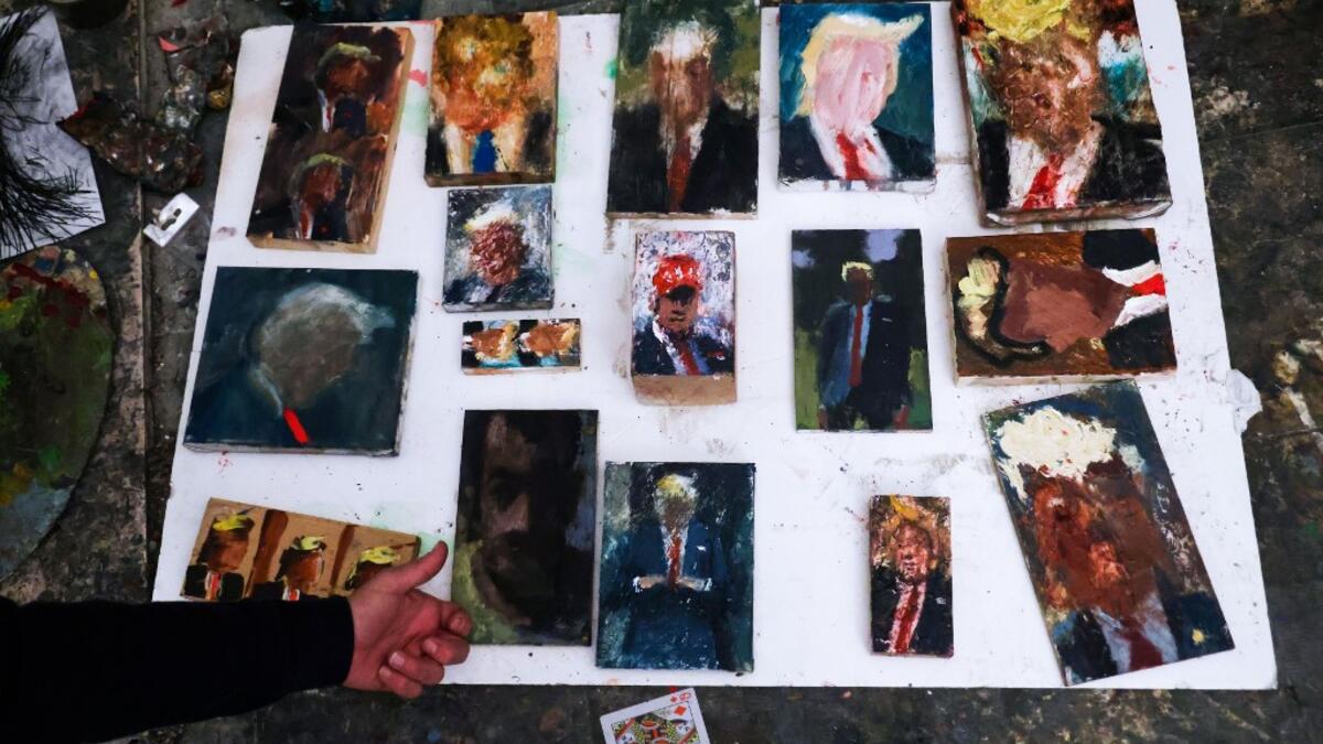 Israeli painter Iddo Markus displays some of his paintings of former US president Donald Trump, at his studio in the northern port city of Haifa, on January 22, 2021. Markus became fascinated by the "tragic figure" of Donald Trump, and the walls and floor of his studio are packed with some 120 portraits of the former US president. Emmanuel DUNAND / AFP