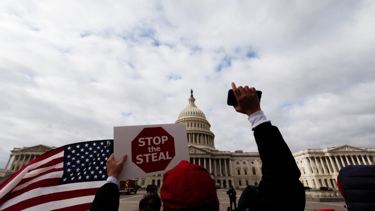 A man with a Stop the Steal sign stands in front of the U.S. Capitol Building on January 6, 2021 in Washington, DC. A pro-Trump mob stormed the Capitol earlier, breaking windows and clashing with police officers. Trump supporters gathered in the nation's capital to protest the ratification of President-elect Joe Biden's Electoral College victory over President Donald Trump in the 2020 election. Jon Cherry/Getty Images/AFP