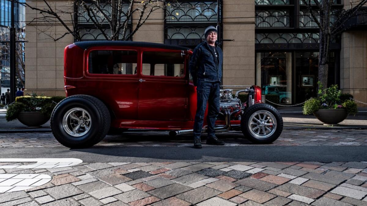 This picture taken on January 16, 2021 shows Kazutaka Fukuda, who works in the construction industry, posing for a photo in front of a 1929 Ford Model A during a gathering of auto enthusiasts in Tokyo. A loose club of fans rolls up most weekends in central Tokyo to show off their Cadillacs, Chevrolets and other modern classic vehicles from the mid to late 20th century. Philip FONG / AFP