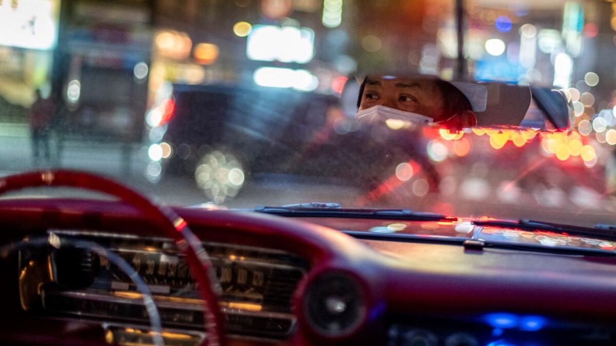This picture taken on January 16, 2021 shows Hiroyuki Wada, who runs a vintage car service company, driving a 1959 Cadillac Coupe DeVille in Tokyo. A loose club of fans rolls up most weekends in central Tokyo to show off their Cadillacs, Chevrolets and other modern classic vehicles from the mid to late 20th century. Philip FONG / AFP