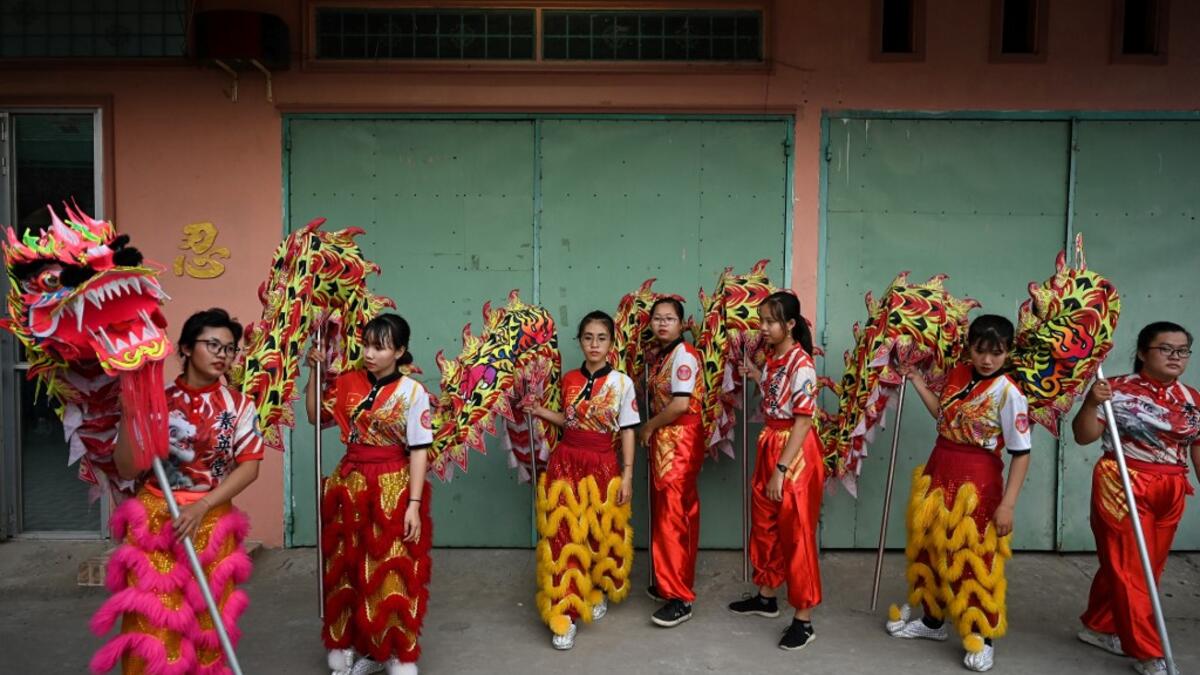 This photograph taken on January 20, 2021 shows Le Yen Quyen (L) practising a dragon dance routine along with other female dancers at the Tu Anh Duong lion and dragon dance school in Can Tho city in southern Vietnam's Mekong Delta. Manan VATSYAYANA / AFP