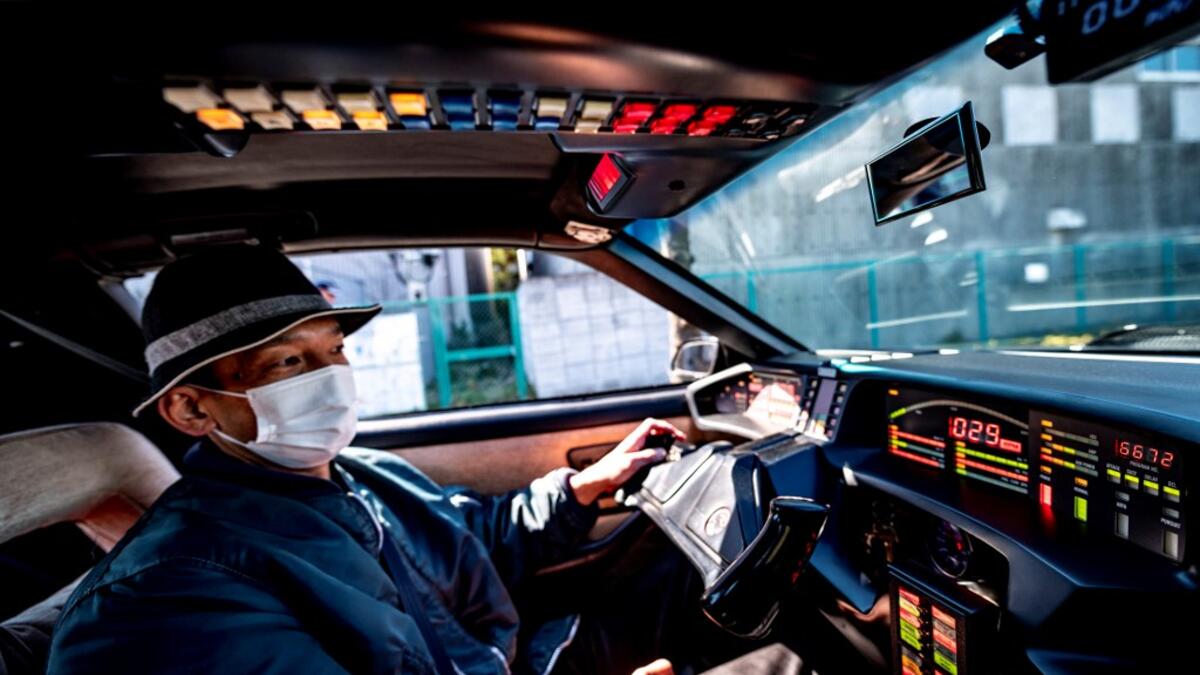 This picture taken on January 31, 2021 shows car enthusiast Masamune Isogai, who works for a logistics company in sales, driving a 1991 Trans Am Knight Rider in Urayasu, an eastern suburb of Tokyo. A loose club of fans rolls up most weekends in central Tokyo to show off their Cadillacs, Chevrolets and other modern classic vehicles from the mid to late 20th century. Philip FONG / AFP
