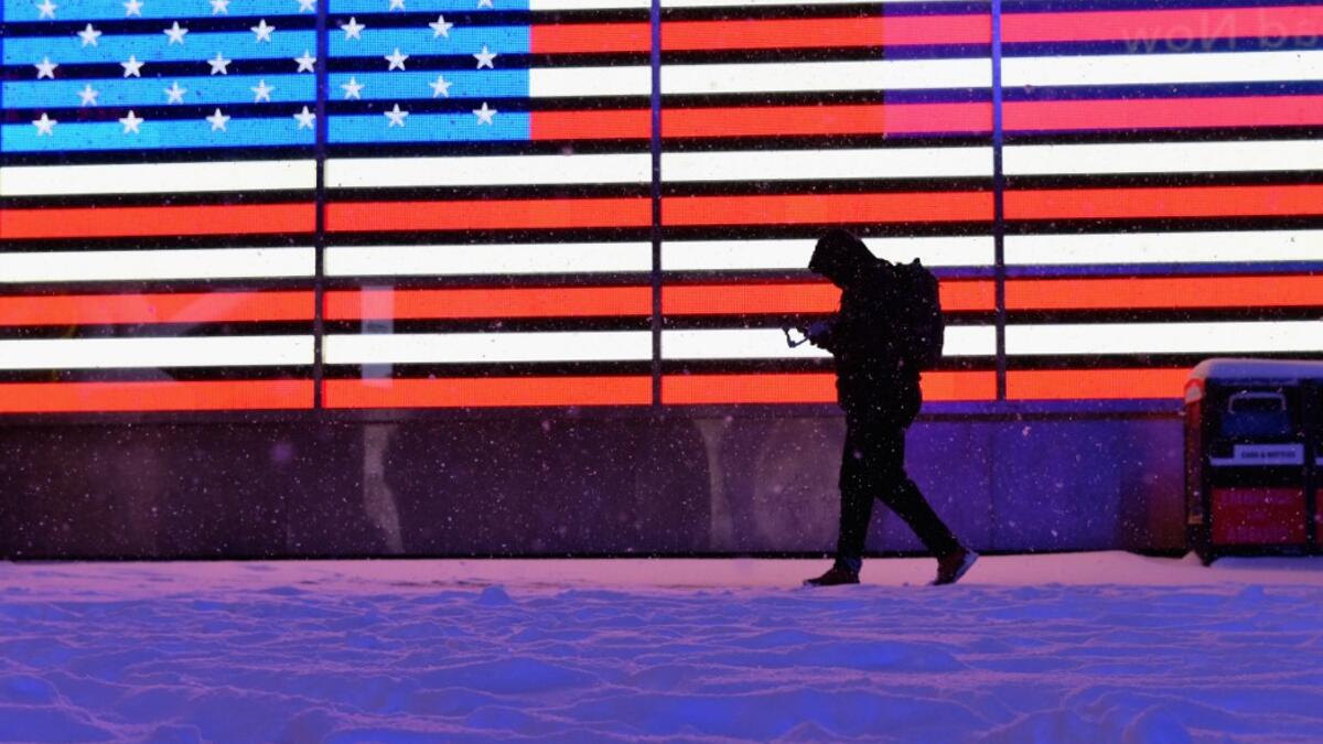 A person walks in the snow at Times Square during a winter storm on February 1, 2021 in New York City. A powerful winter storm is set to dump feet of snow along a stretch of the US east coast including New York City on February 1, 2021, after blanketing the nation's capital. Angela Weiss / AFP