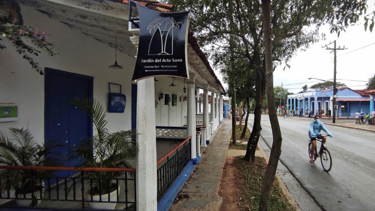 A man passes by a closed handicraft shop in Vinales, Cuba, on January 28, 2021. At the foot of the majestic rock formations of Vinales, the terraces of the restaurants look empty and the lodgings have closed. With the arrival of COVID-19, the incipient prosperity of this Cuban town came to a halt and people abandoned tourism jobs to return to work the land. YAMIL LAGE / AFP